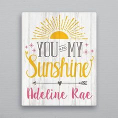 a wooden sign that says you are my sunshine and an arrow on the front with pink,