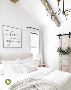 a bedroom with white bedding and wooden beams