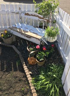 a bench made out of an old door and some plants in pots next to it