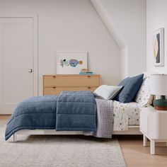 a bedroom with white walls and blue bedding