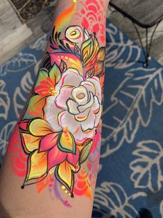 a woman's arm with flowers painted on it