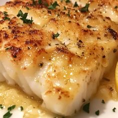 a white plate topped with fish and lemon slices