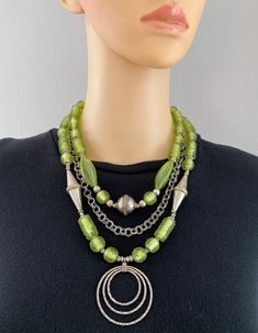 One-of-a-kind handcrafted multi-strand statement necklace. Beads: 3 strands of German lampwork glass, Afghan silver, Murano glass, sterling silver pendant, with silver-plated chain Dimensions: approximately 21" with 2" pendant + 2.5" extender Make a Statement with this elegant necklace! ﻿Free Shipping ﻿Refund Policy Beautiful Beaded Necklaces, Silver Statement Necklace, Green And Silver, Necklace Beads, Silver Necklace Statement, Elegant Necklace, Elegant Necklaces, Multi Strand Necklace, Multi Strand