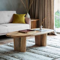 a living room with a couch, coffee table and rug in front of the window