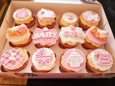 a box filled with cupcakes covered in pink and white frosted icing