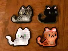 four perlery pixelated cats sitting on top of a wooden table