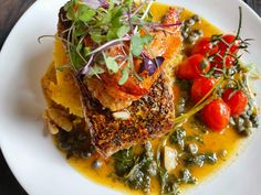 a white plate topped with fish and vegetables