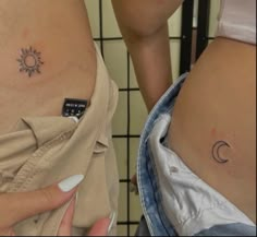 two women with small tattoos on their stomachs, one has a sun and the other has a moon