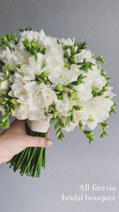 a person holding a bouquet of white flowers