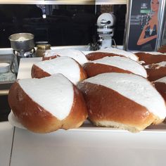 there are many rolls with white frosting on them