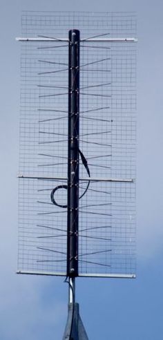 a very large antenna on top of a tall pole with a sky background behind it