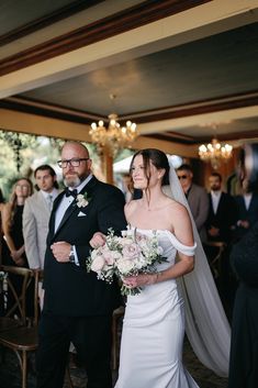 a bride and groom walking down the aisle