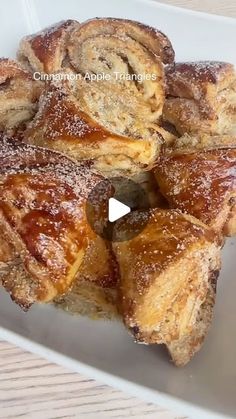 cinnamon apple turnovers on a white plate covered in powdered sugar