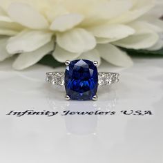 "The ring pictured is a lab created blue sapphire and moissanite #6398 Rose Gold is available upon request as a custom order and is a final sale (non refundable, non returnable, non exchangeable) Moissanite may take up to 5 to 10 business days to complete and ship, sometimes sooner. -Approximate total carat weight: approx. 6.00ctw diamond equivalent -Center Stone Size: 11x9mm - approx. 5.00ct diamond equivalent -Center Stone Shape: elongated cushion cut -Gem Type: lab created blue sapphire -Ston Cushion Cut Gia Certified Sapphire Ring, Cushion Cut Sapphire Ring With Cubic Zirconia Accent Stones, Blue Radiant Cut Lab-created Sapphire Ring, Sapphire Diamond Ring With Prong Setting Cushion Cut, Sapphire Radiant Cut Ring With Accent Stones, Sapphire Ring With Radiant Cut And Accent Stones, Blue Sapphire Ring Radiant Cut For Wedding, Anniversary Sapphire Ring With Prong-set Moissanite, Gia Certified Cushion Cut Sapphire Jewelry