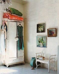 a room with a white cabinet and chandelier hanging from it's ceiling