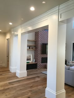 an empty living room with wood floors and white walls, is shown in this image