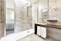 a bathroom with a walk in shower next to a sink and a mirror on the wall