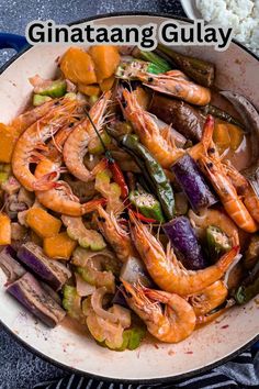 a bowl filled with shrimp and vegetables next to rice