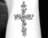 a black and white photo of a cross with flowers on it's side tattoo