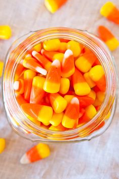 a jar filled with candy corn on top of a table