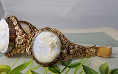 "Here's an antique carved shell cameo bracelet, set in 10k gold. It features 3 cameos, the middle one being larger than the two on the sides. The setting has a delicate openwork construction of leaves, mounted onto a wire backing. The center link is 1.1/2\" wide, and the two sides are 1.1/4\". It has a hidden box clasp and safety chain, and is stamped, '10k' on the back of the clasp. Interior circumference is 7\". Completely original with no repairs and no damage. Thanks for looking." Antique Cabochon Bracelets For Wedding, Vintage Carved Bracelet For Wedding, Ornate Cameo Jewelry For Formal Occasions, Victorian Cameo Jewelry For Formal Occasions, Victorian Carved Jewelry For Formal Occasions, Formal Victorian Carved Jewelry, Vintage Carved Jewelry For Formal Occasions, Vintage Intaglio Bracelets For Formal Occasions, Elegant Gold Cameo Bracelets