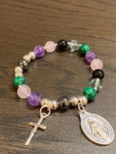 Item details Handmade Rosary Bracelet for Women Stretch Muti-colored Bracelets, Miraculous medal Medal and small cross Rosary Beads are a mix of rose quartz, malachite, amethyst, flourite, black tourmaline and hematite The size of the rosary bracelet is 6.5 inches. This will be a great gift for confirmation! A unique and beautiful personalized rosary bracelet! It will make a perfect religious themed gift or inspiration for yourself. The beads used on every piece are handpicked. We make sure that Spiritual Beaded Cross Bracelets, Nickel Free Cross Bracelet With Spiritual Style, Nickel-free Cross Bracelet For Spiritual Style, Spiritual Cross Bracelets, Spiritual Cross Charm Bracelet Gift, Cross-shaped Rosary Bracelet With 8mm Beads, Personalized Rosary, Handmade Rosary, Cross Rosary