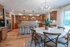 a large kitchen with wooden cabinets and marble counter tops, an island in the center