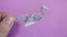 a person is holding an origami bird on a purple background with the word love written in it