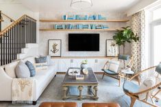 a living room filled with furniture and a flat screen tv mounted on a wall above a fireplace