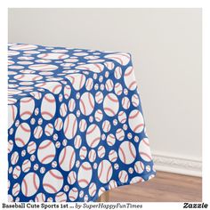 a blue and white table cloth with red and white baseballs on it in the corner