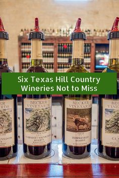 seven texas hill country wineries not to miss bottles on a table with the words, seven texas hill country wines not to miss