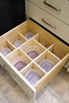 an open drawer with plastic cups in it