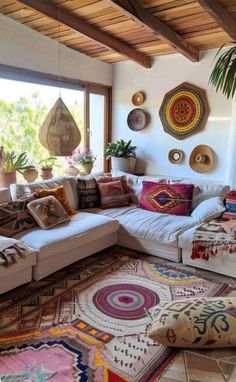 a living room filled with lots of furniture and pillows on top of a rug covered floor