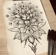 a drawing of a flower on a piece of paper next to two black ink pens