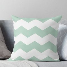 a green and white chevroned pillow on a couch