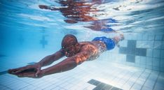 a man swimming underwater in a pool