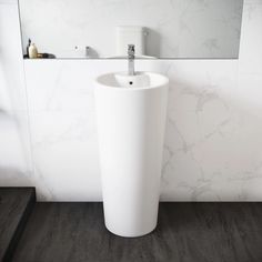 a white pedestal sink in a bathroom next to a mirror