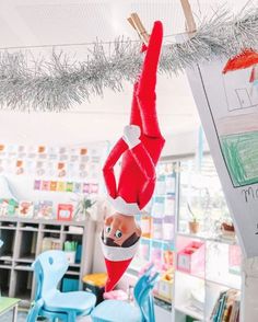 an elf hanging upside down in a classroom