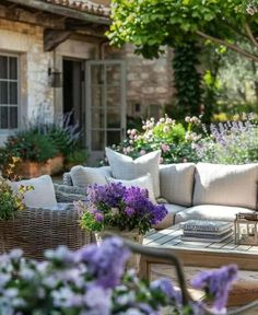 an outdoor living area with wicker furniture and flowers