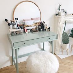 a table with makeup and other items on it in front of a fire place,