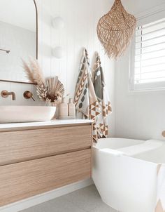 a bathroom with a sink, toilet and bathtub covered in decorative towels hanging from the ceiling