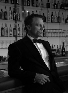 a man in a tuxedo standing at a bar