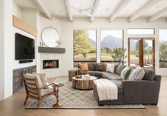 a living room filled with furniture and a flat screen tv mounted on the wall next to a fire place