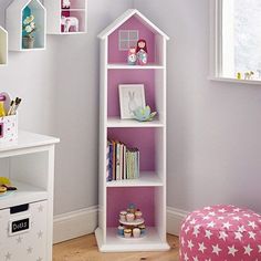 a pink and white doll house shelf in a child's room