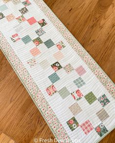 a quilted table runner on a wooden floor