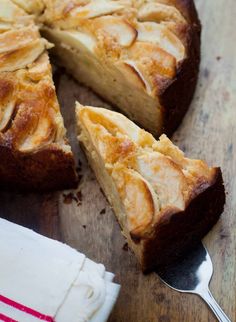 a close up of a pie on a wooden table with a slice missing from it