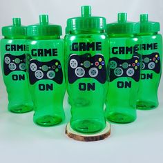 four green water bottles with game controllers on them