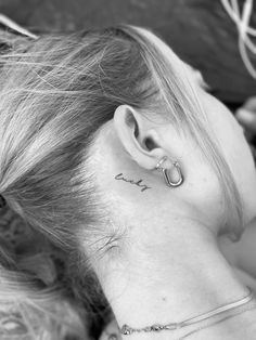 a woman with a small tattoo on her ear