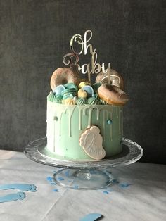 a cake decorated with doughnuts and baby's name on top is sitting on a table