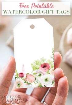 a hand holding up a watercolor gift tag with flowers on it and the words free printable watercolor gift tags